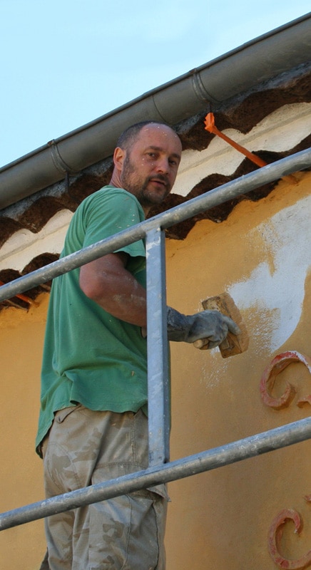 Réalisation de badigeon à la chaux sur murs en façade en extérieur à Toulouse.